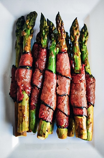 BBQ Pastrami Wrapped Asparagus glazed with BBQ sauce baked until crispy on a sheet pan