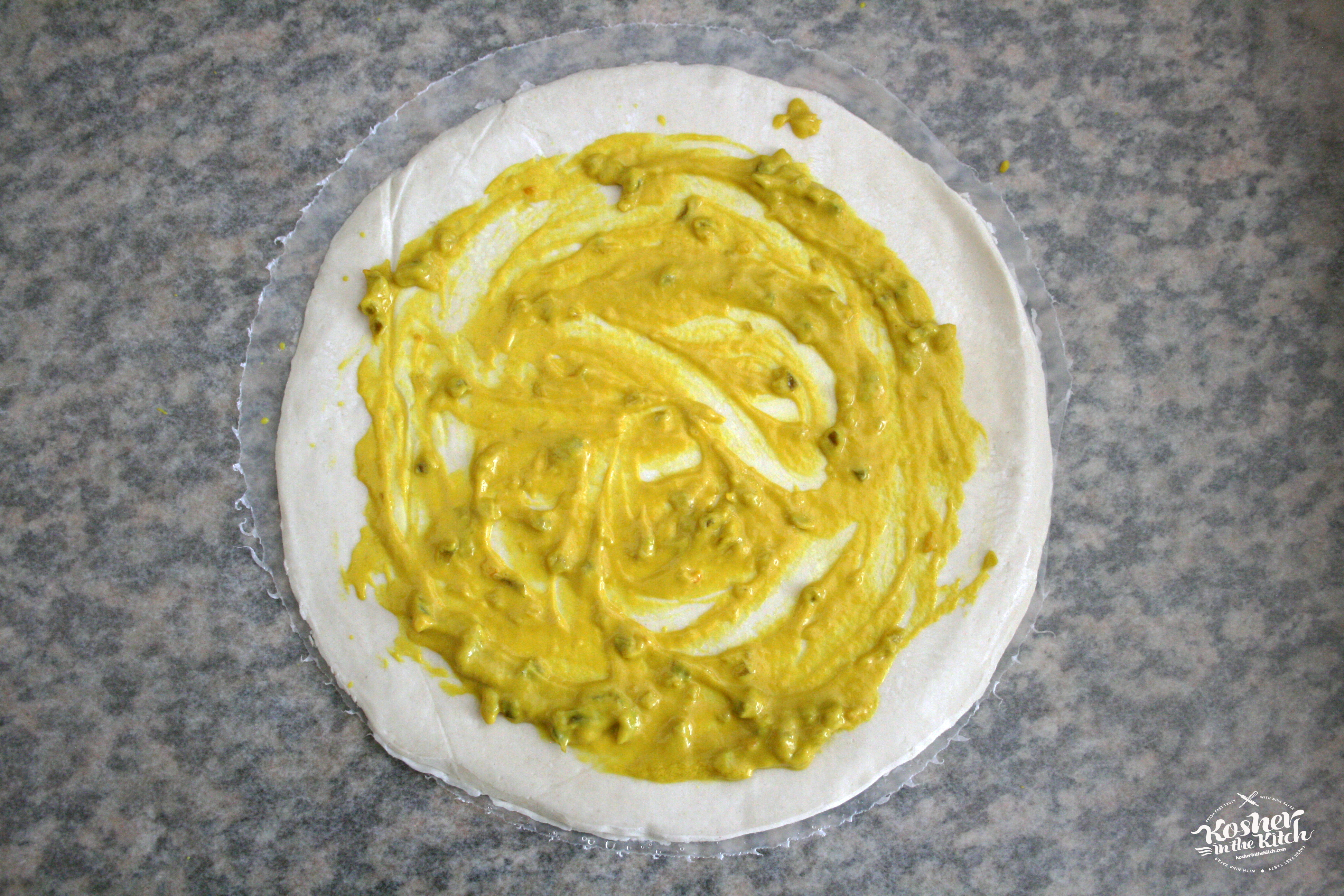 Spread mustard over dough
