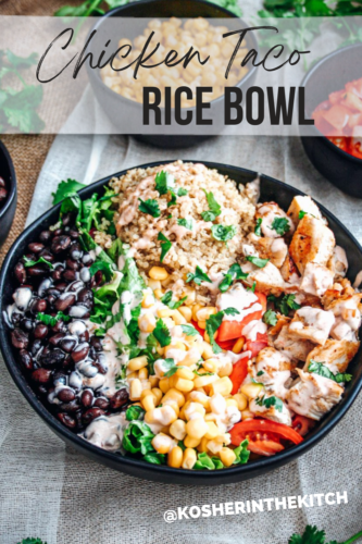 Large black bowl filled with spiced rice, diced chicken, black beans, corn salad,